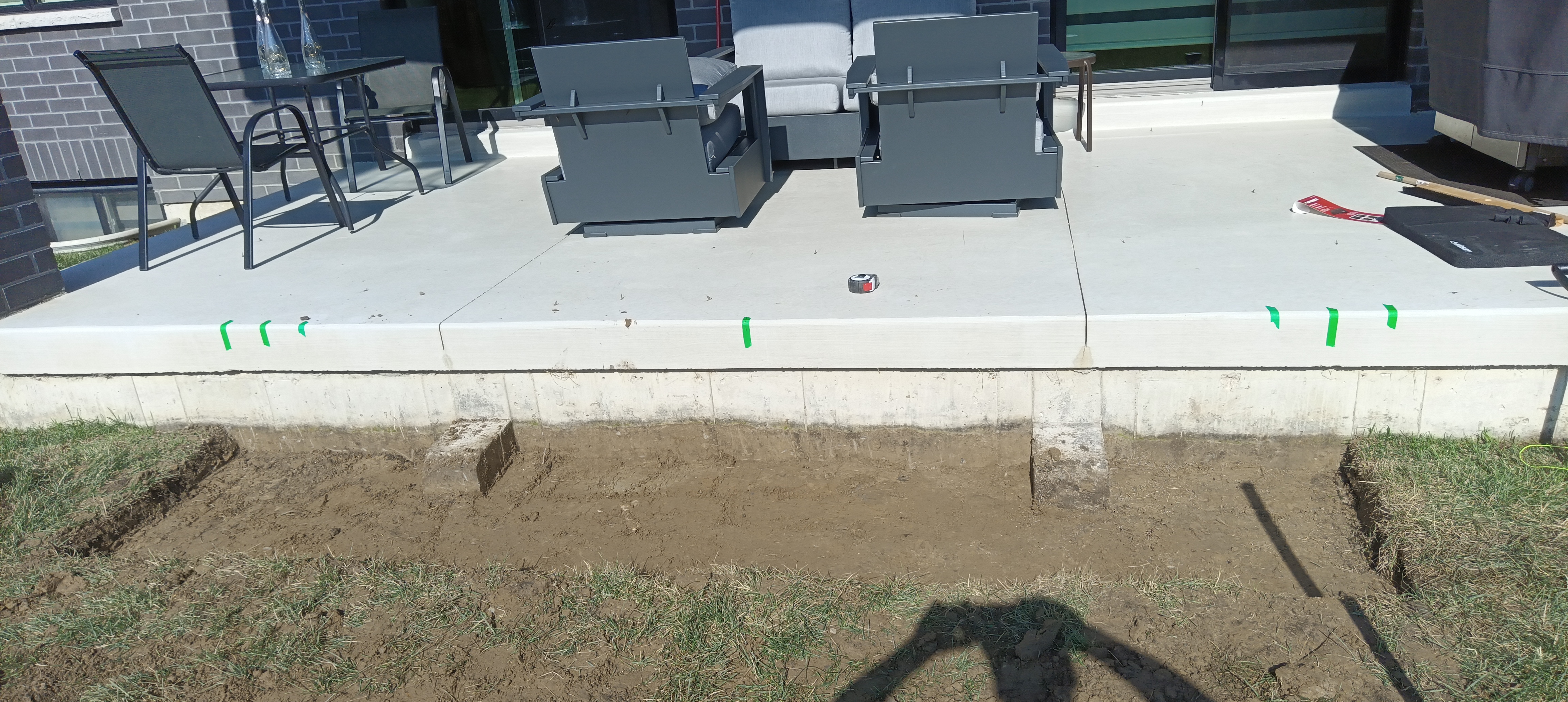 Raised patio edge with excavated ground before the landing step was built