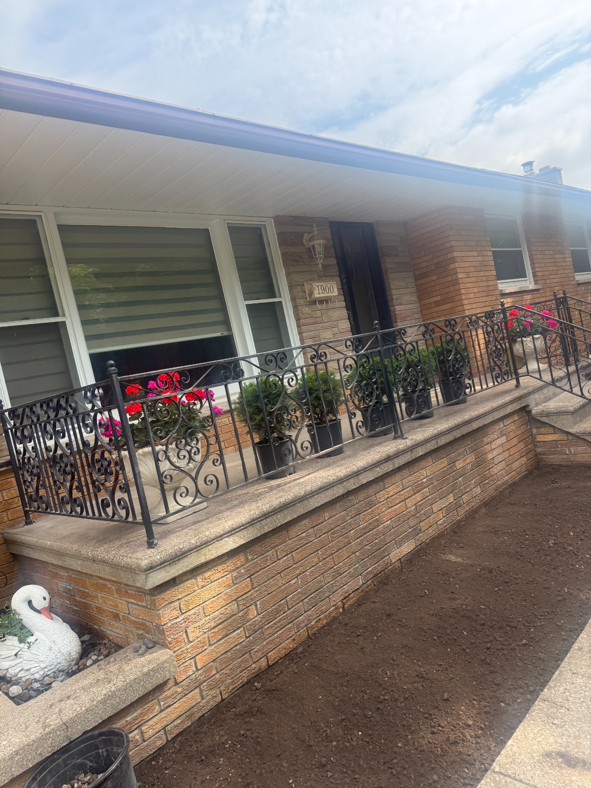 Finished front porch with ornamental iron railing